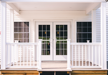 White patio entrance with French doors and railing.